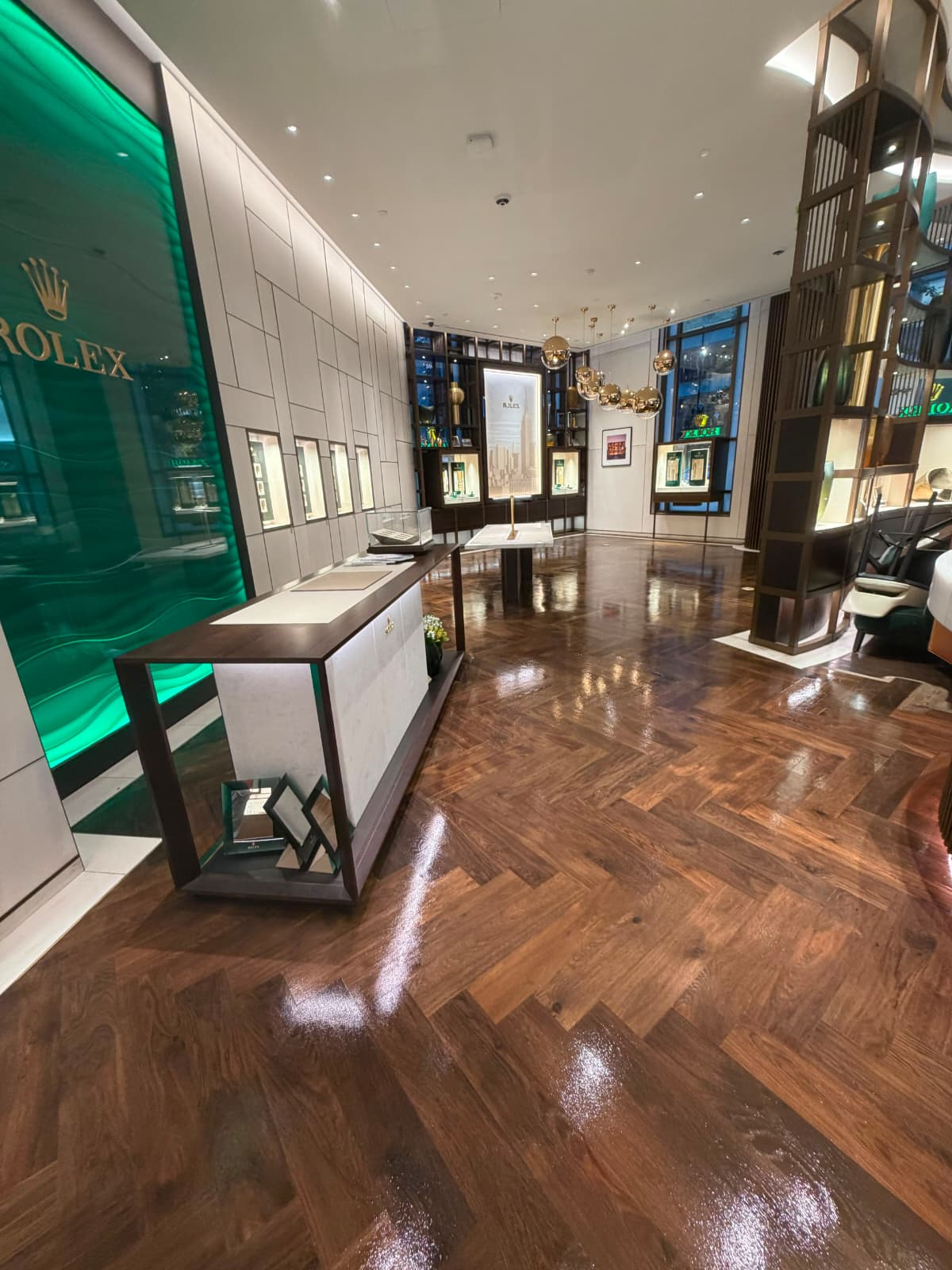Walnut herringbone floor refinished with a neutral stain at the Bucherer 1888 flagship on Madison Avenue