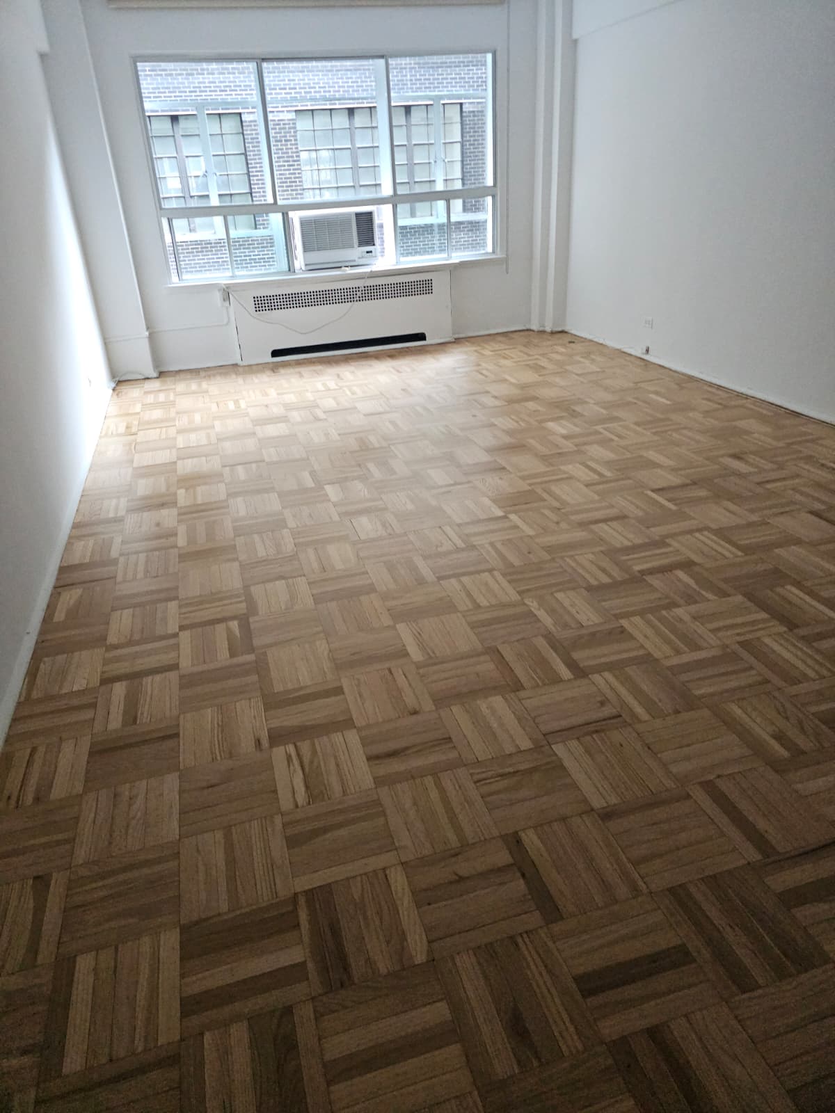 Refinished parquet floor in natural color with a satin finish in Midtown West