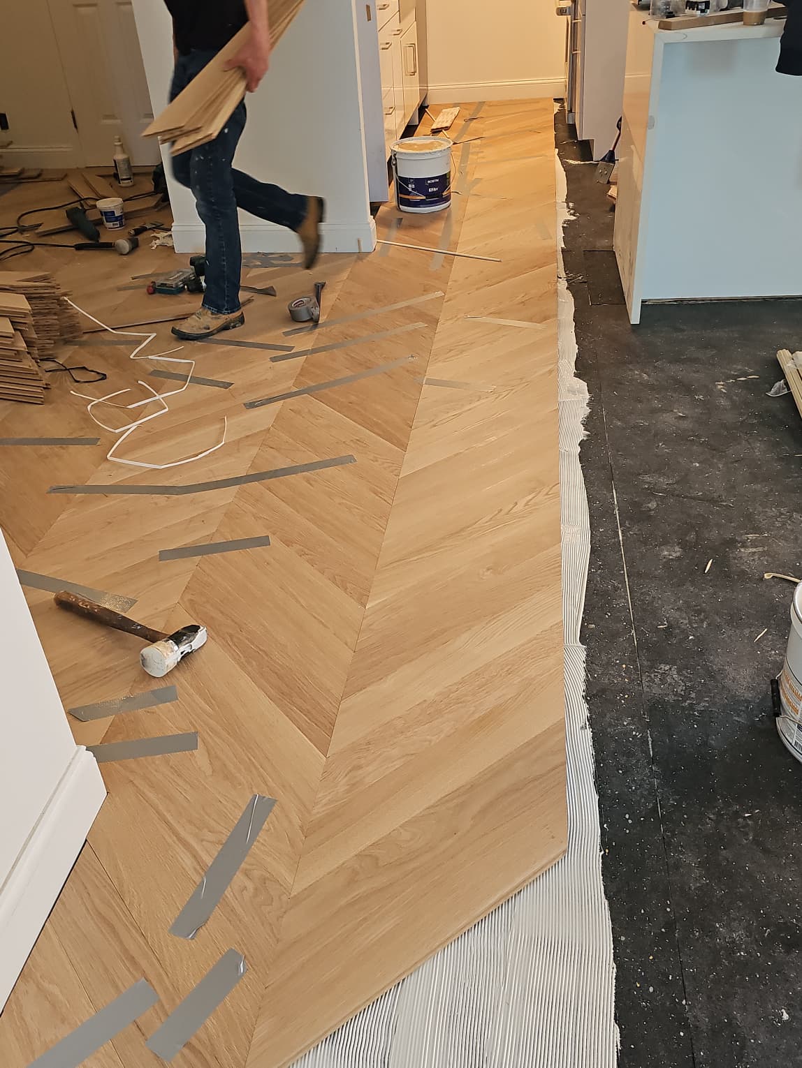 White oak chevron being glued down to the prepared concrete slab